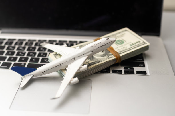 飞机，钱和键盘。在一张灰色的木桌上在线购买机票图片下载