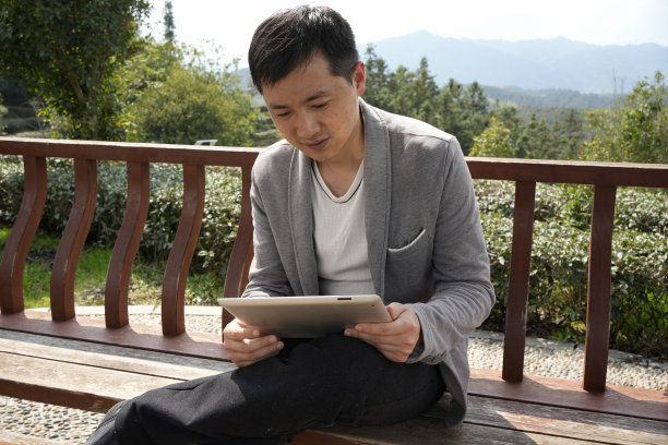 男子在户外使用平板电脑图片下载