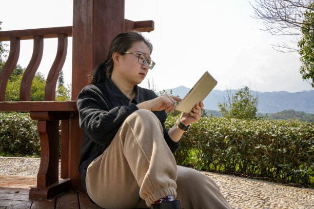 女子在户外使用平板电脑图片下载