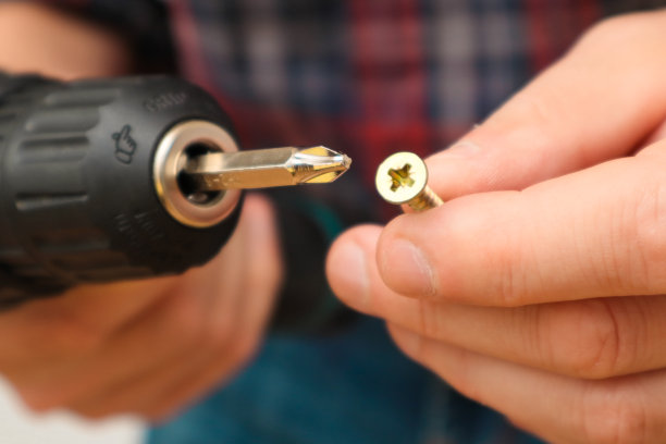 手工工人使用电动螺丝刀工作。用便携式钻头固定木结构的木匠图片下载