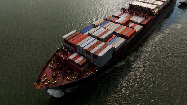 货运集装箱船在海上航行，进出口货物并将产品分销给世界各地的经销商和消费者，通过集装箱船运输业务服务。4 k的视频图片下载