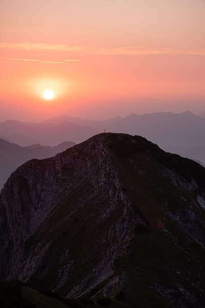 美丽的日出在山上，五彩缤纷的天空，一个美丽的山脊和山顶交叉在视线之内。图片下载
