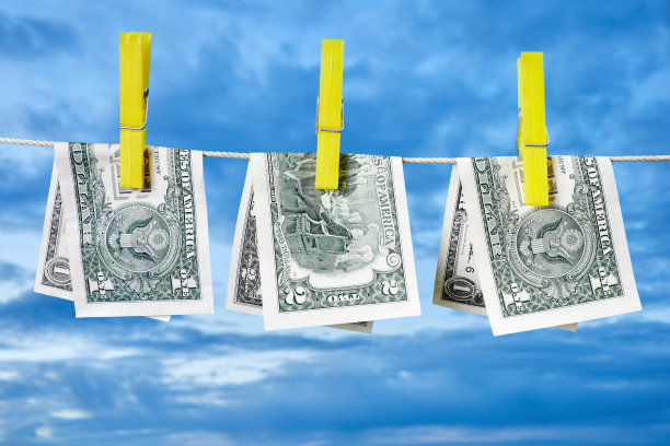 用晒衣夹固定的1美元和2美元钞票在蓝天下晒干图片下载