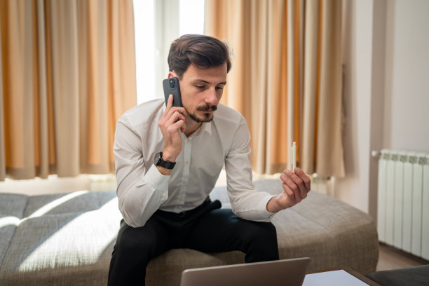 一个在酒店房间工作的成年白人男子打电话图片下载