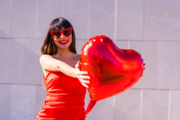 一个美丽的白人女孩在情人节与一个心形气球恋爱的照片图片下载