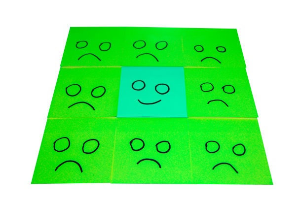 不快乐和快乐的概念。蓝色和绿色便利贴的背景。快乐的便利贴是不快乐便利贴中的一种。图片下载