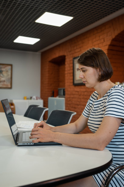 孕妇坐在办公桌前，电脑在办公室。图片下载