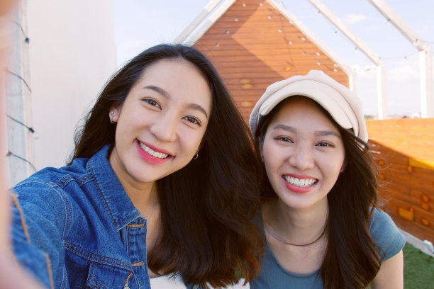 年轻亚洲女性的POV与朋友拿着手机自拍视频通话图片下载