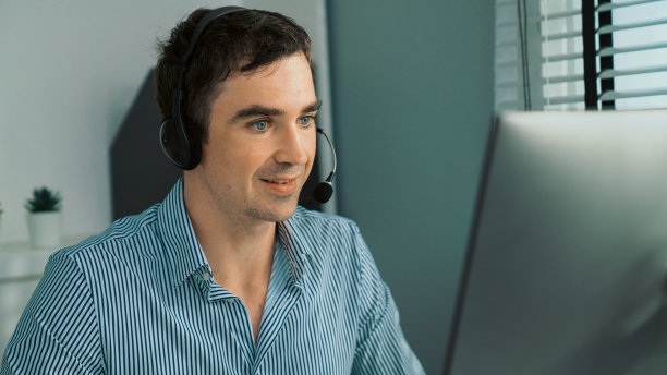 在办公室与客户一起工作的有能力的男性操作员。图片下载