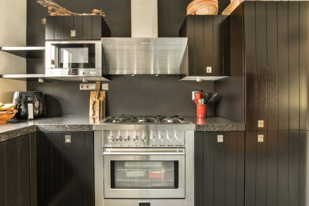 一个有黑色橱柜和白色烤箱的小厨房图片下载