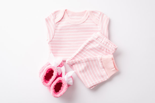 女婴概念。顶部视图照片的粉红色婴儿衣服衬衫裤子和针织靴子孤立的白色背景图片下载
