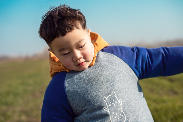亚洲小男孩在田野里快乐地奔跑图片下载