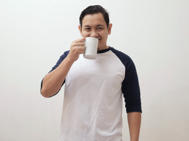 快乐的亚洲男人喝着一杯咖啡或茶图片下载