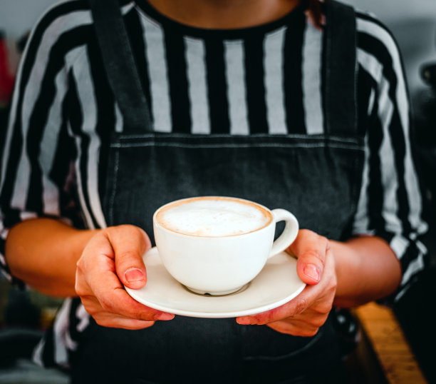 一杯咖啡卡布奇诺菜单准备在手中的女咖啡师在咖啡店图片下载