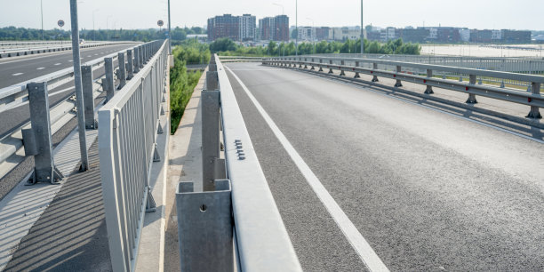 桥面以金属栏杆、高层建筑为背景图片下载