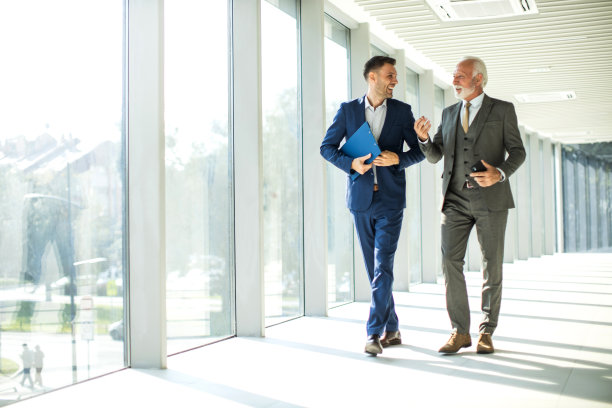 高级和初级管理人员走过走廊，交谈图片下载