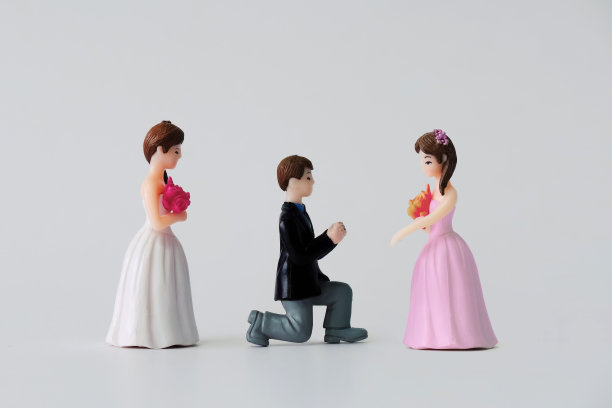 白色背景上孤立的微型婚礼娃娃。新郎选择不同的新娘结婚。夫妻关系主题。图片下载