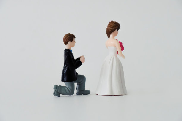 婚礼新人主题——新娘转身离开跪在地上乞求的新郎;拒绝，改变心意;孤立在白色背景上。图片下载