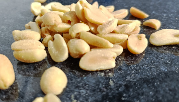 去皮的咸花生在黑色背景上。特写镜头。图片下载