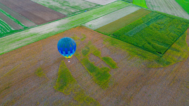 高空鸟瞰图热气球在傍晚飞过一片农田，高角度拍摄图片下载