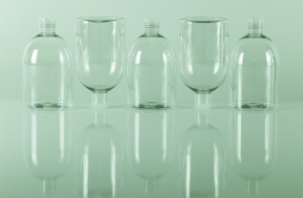 静物透明塑料瓶反射与绿色色调图片下载