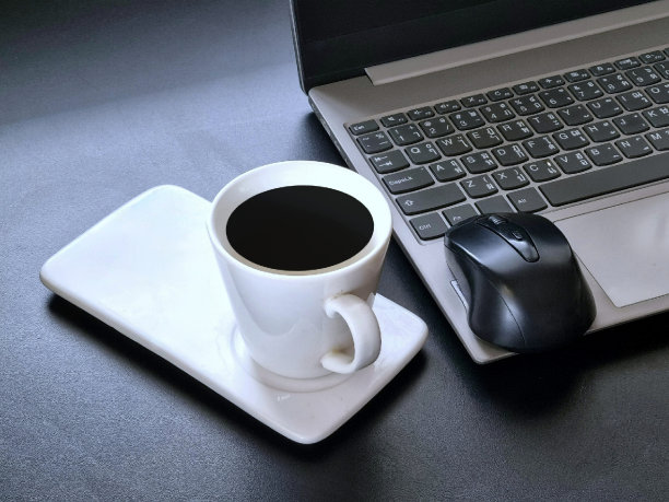 笔记本电脑放在办公室的桌子上，还有一杯咖啡和鼠标图片下载