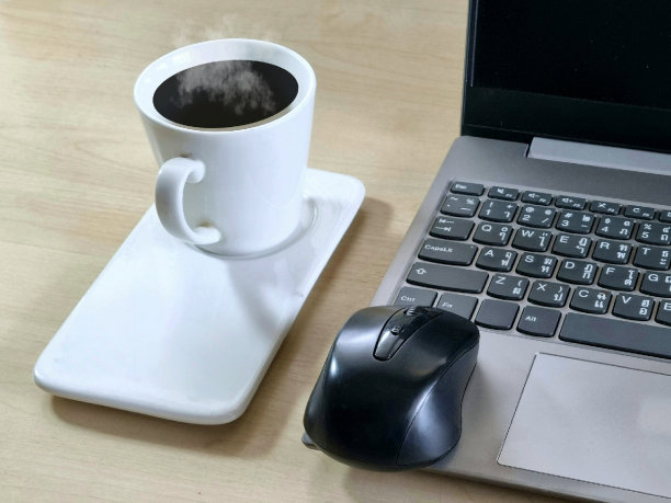 笔记本电脑放在办公室的桌子上，还有一杯咖啡和鼠标图片下载