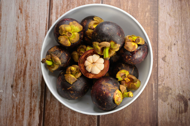 一个开放的山竹(山竹)水果，露出可食用的果肉和完整的水果图片下载