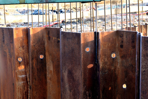 在搅拌机和带软管的泵的帮助下，为地下车库的地板浇筑混凝土。混凝土钢筋线缠绕在灰色网格中。大型建筑的整体结构图片下载