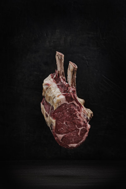 垂直拍摄的生战斧牛排与麻绳在黑暗的背景图片下载