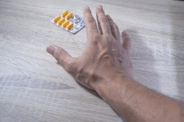 人的手拿着药丸，浅色的木头背景图片下载
