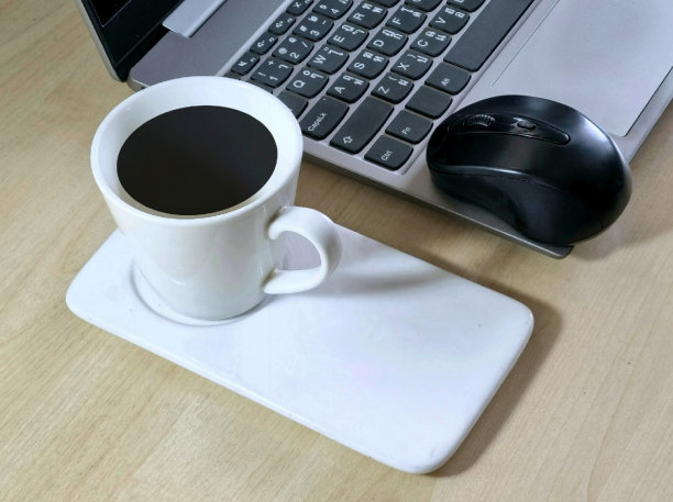 笔记本电脑放在办公室的桌子上，还有一杯咖啡和鼠标图片下载