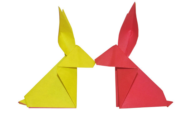 一只红色的折纸兔子和一只橙色的兔子面对面图片下载