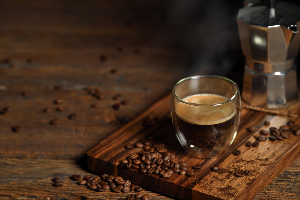 老木头背景上有烟雾和咖啡豆的咖啡杯。摩卡壶和咖啡杯图片下载
