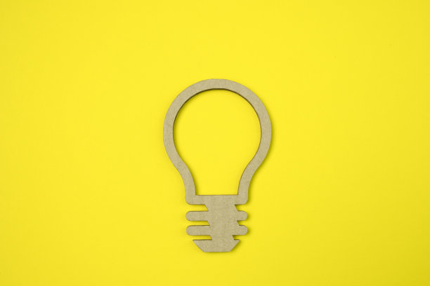 黄色背景上剪纸制成的灯泡。经营理念。图片下载