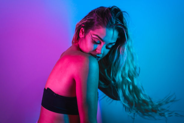 一个金发的白人女孩在夜总会画了眼妆，安排在一个蓝色的背景图片下载