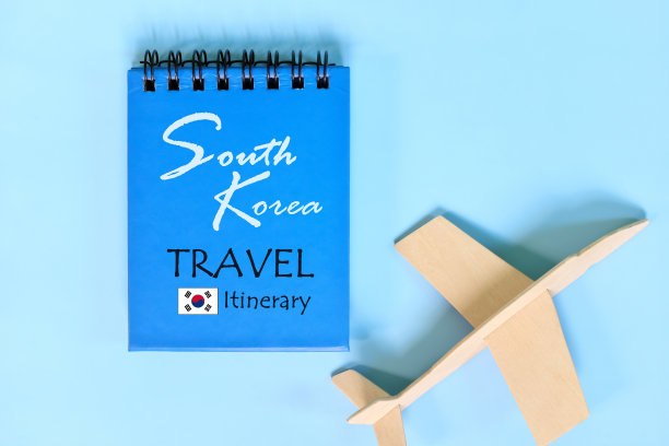 韩国旅行计划或行程写在蓝色记事本与国旗和木制飞机。图片下载