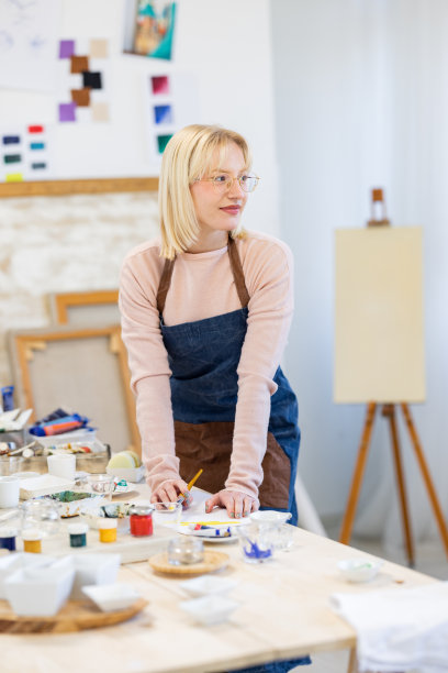 年轻的艺术家正在为绘画混合和准备颜料图片下载