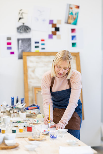 年轻的艺术家正在为绘画混合和准备颜料图片下载