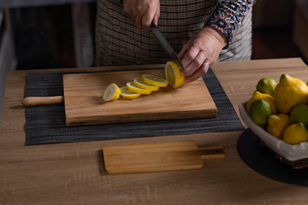 女人切柠檬和酸橙的手图片下载