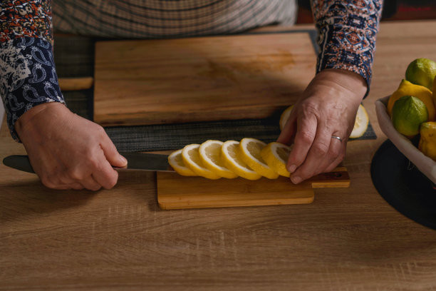 女人切柠檬和酸橙的手图片下载