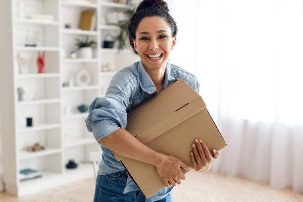 快乐的阿拉伯女士客户拿着纸板箱包装在家里图片下载