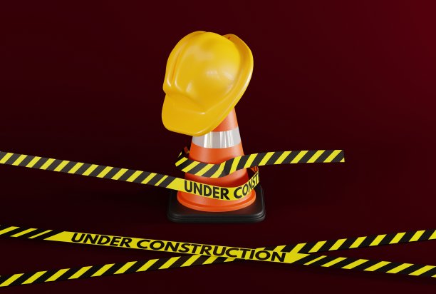 头盔挂在交通锥上，胶带上写着“正在施工中”。图片下载