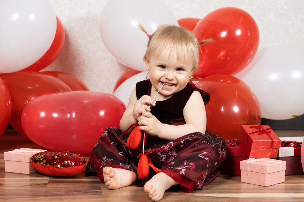 可爱的金发小女孩在情人节玩木棍上的心。图片下载