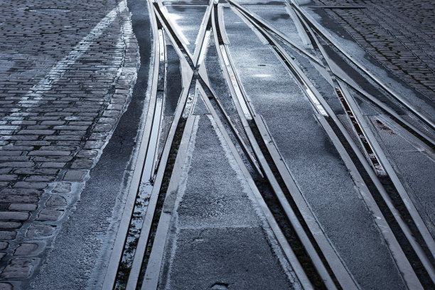 潮湿的城市街道上的有轨电车轨道图片下载
