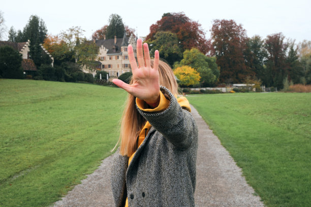 女孩用手挡住她的脸。交际心理学中的消极防御概念。女子拒绝了提议，并做了暂停的手势图片下载