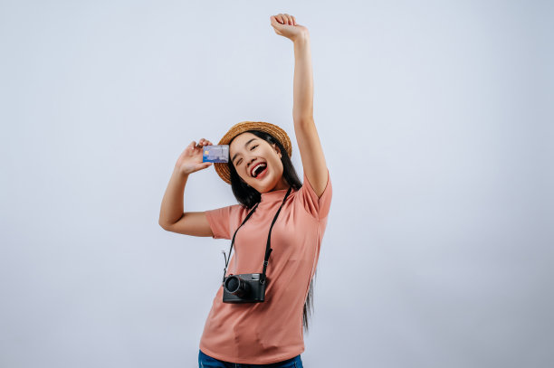 年轻美丽的旅行者女性戴着草帽，摆出数码相机图片下载