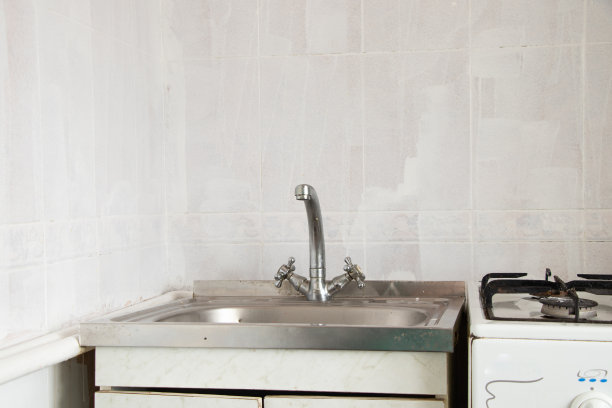 厨房里旧的水槽和水龙头贴在白色瓷砖的背景上图片下载