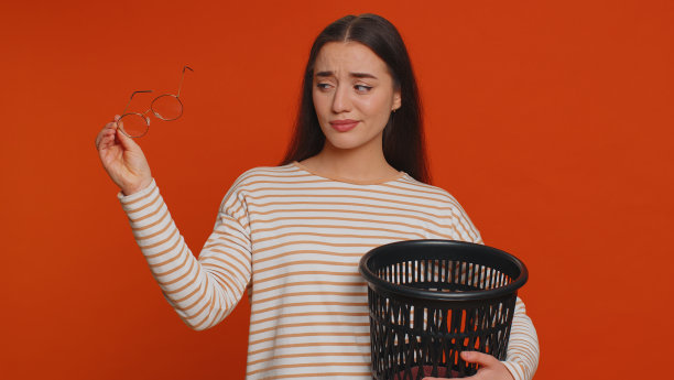 一名女子在接受眼科激光治疗手术后，将眼镜扔进垃圾箱图片下载
