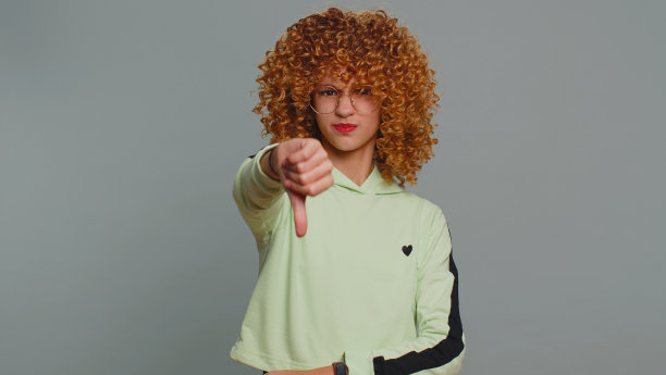 心烦意乱的十几岁的小女孩，拇指向下，不喜欢糟糕的工作，反对，不满的反馈图片下载